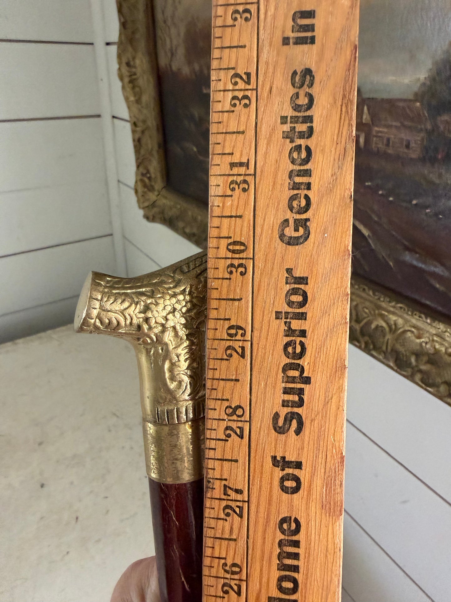 antique-style walking cane with a brass handle featuring an embossed pattern