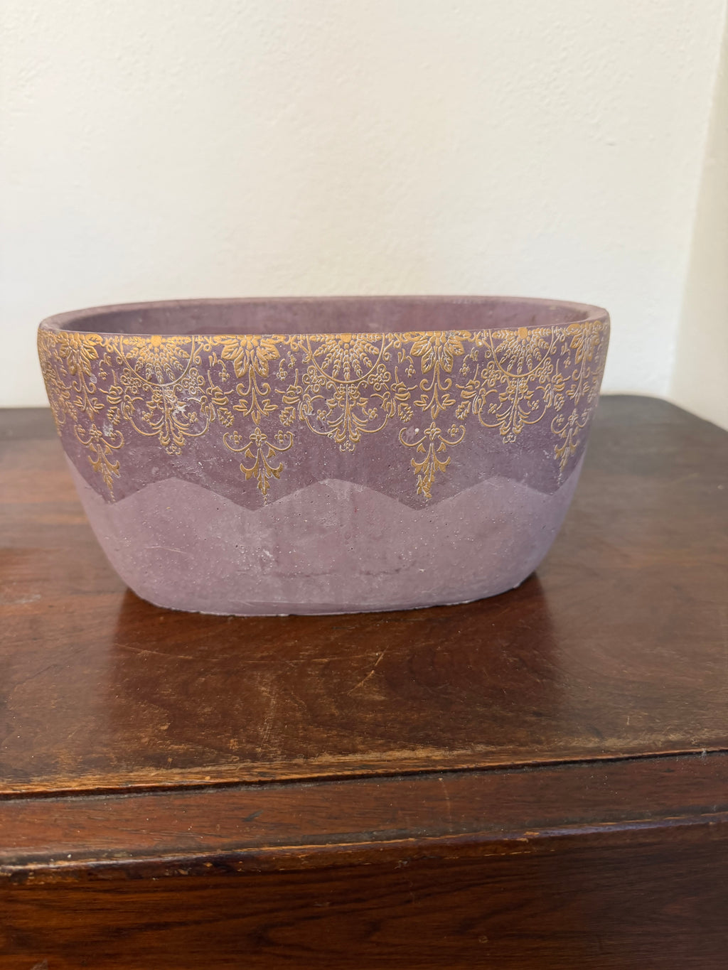 Cement planter with decorative design and purple hue