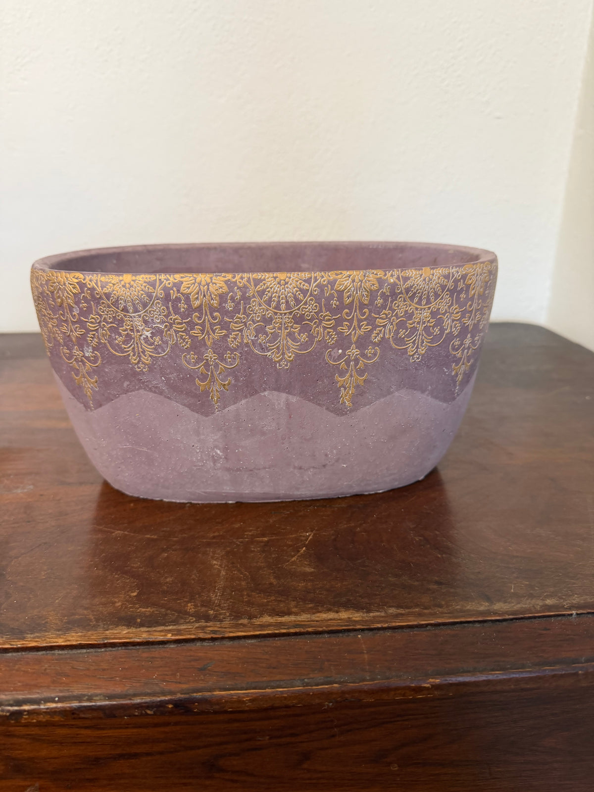 Cement planter with decorative design and purple hue