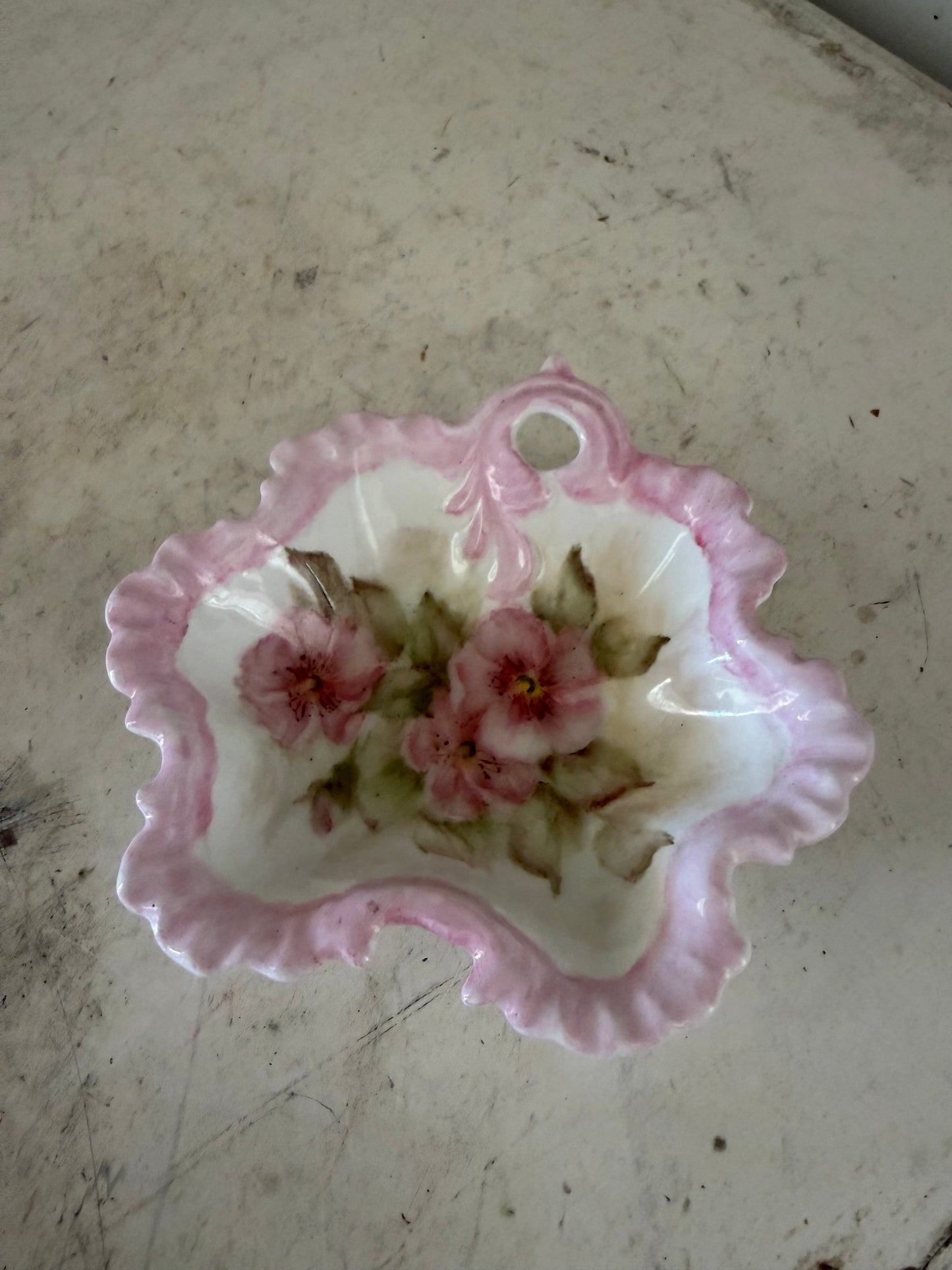 vintage pink and white floral porcelain bowl features a scalloped edge and a delicate handle