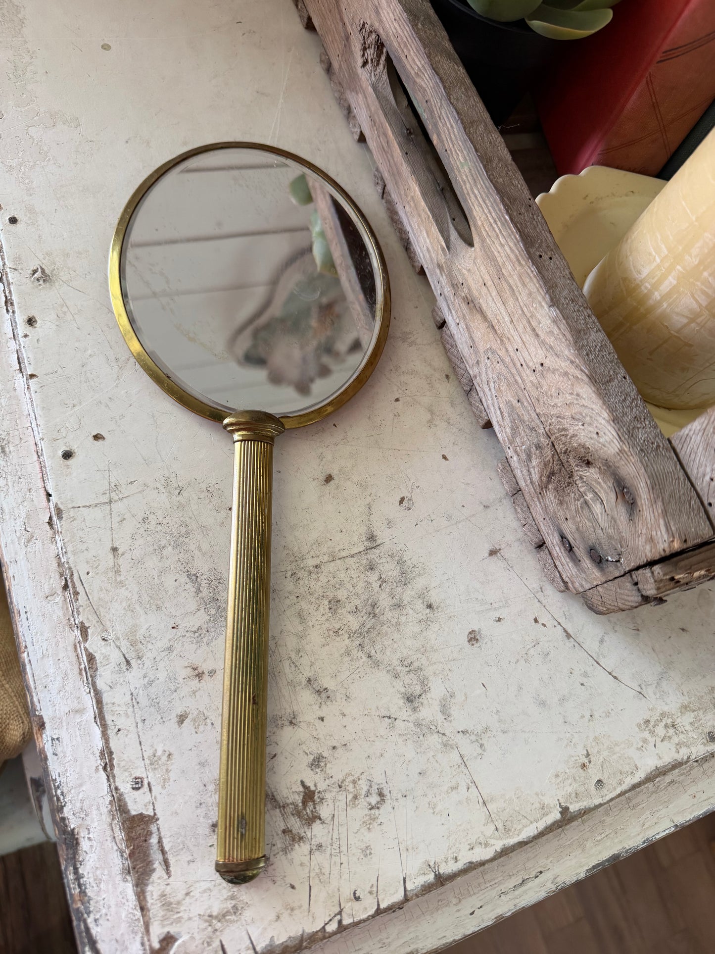 Art Nouveau style hand mirror with a yellow celluloid back and a long, slender handle