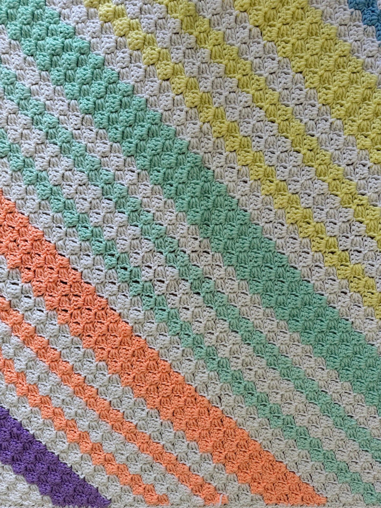 Peach, green, yellow, white, blue and purple striped afghan