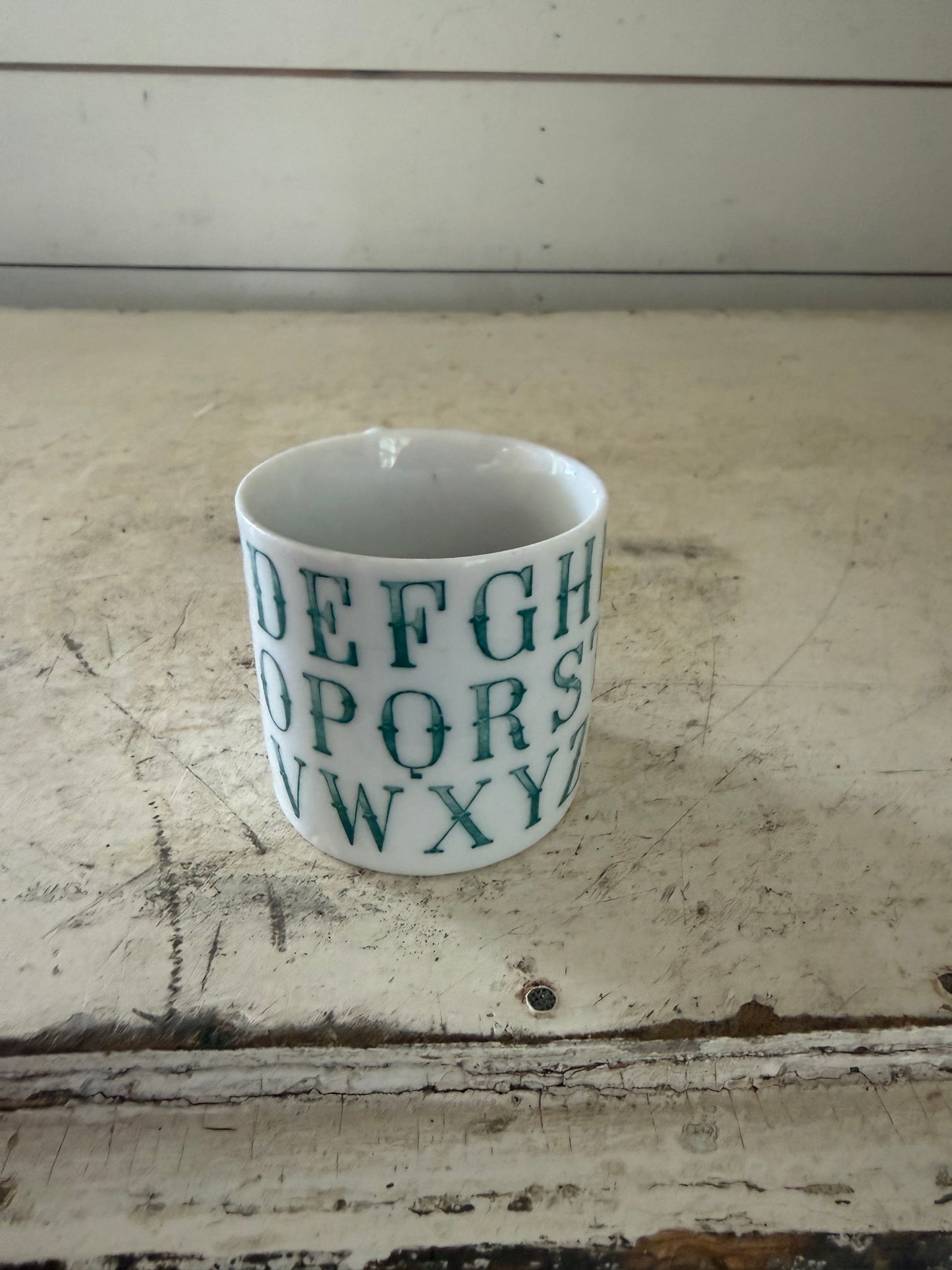 Vintage German porcelain alphabet mug featuring dark green transferware lettering