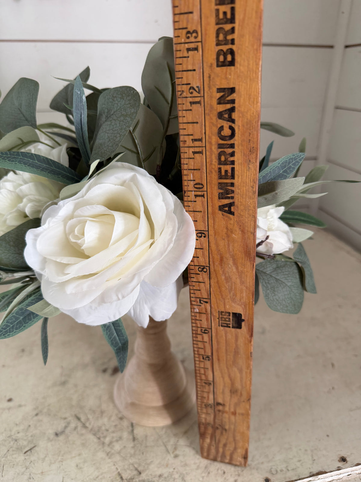 Turned wood pedestal with flowers on top
