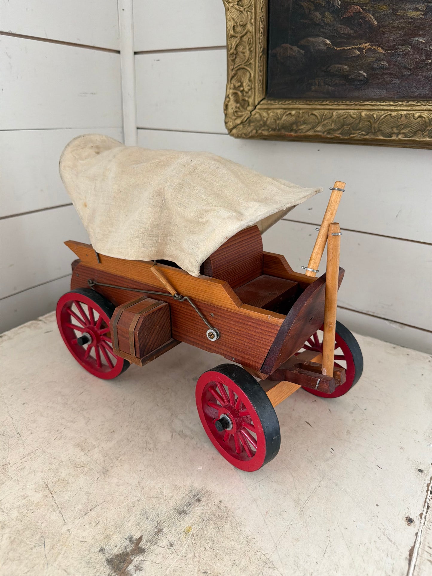 Vintage Wooden Folk Art Covered Wagon Pull Toy featuring distinct red-painted wheels