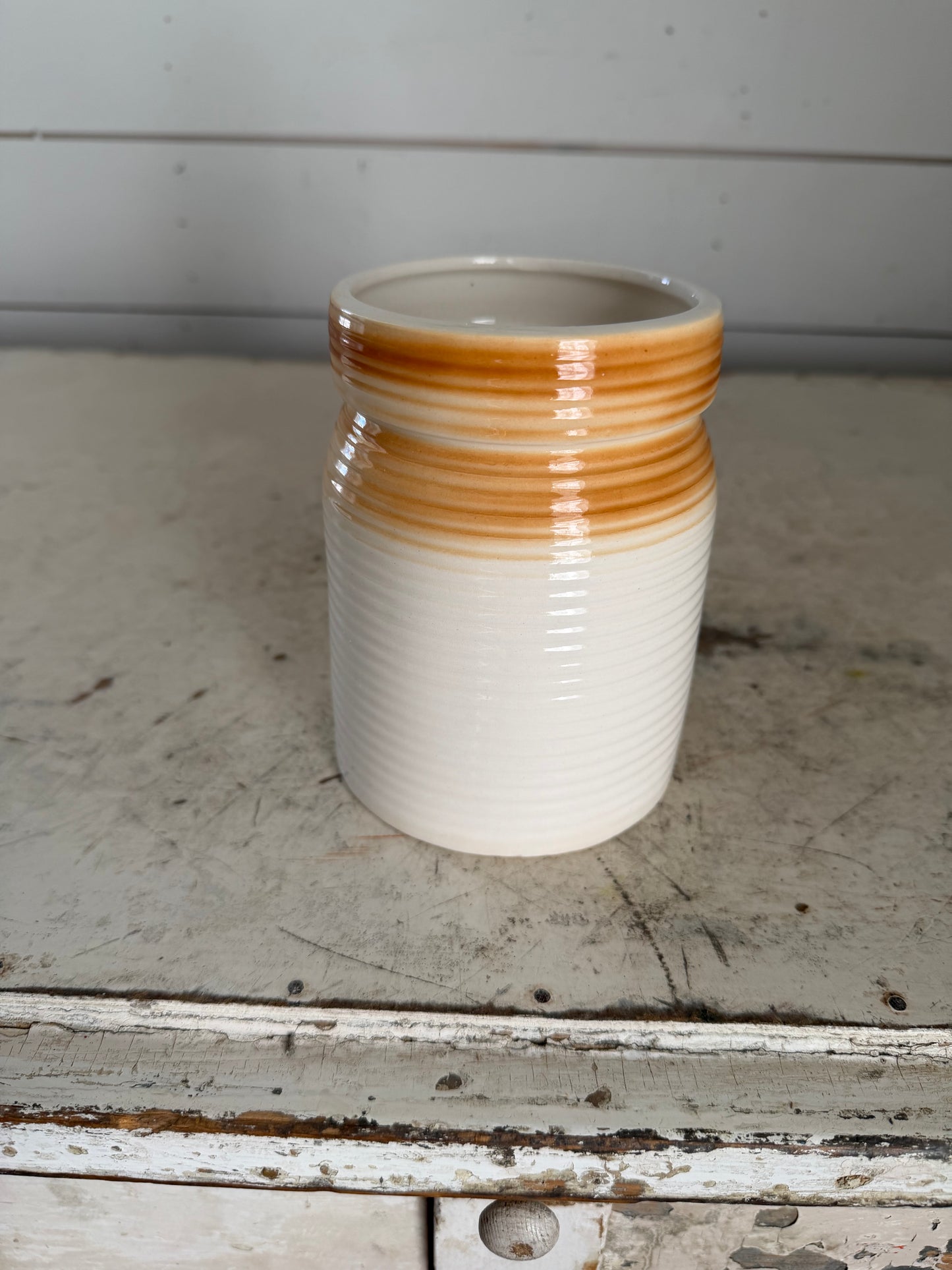 Small cream colored ribbed canister