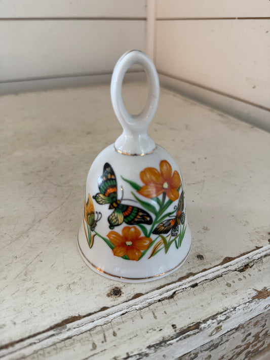 Vintage porcelain bell with butter, butterflies, and orange flowers
