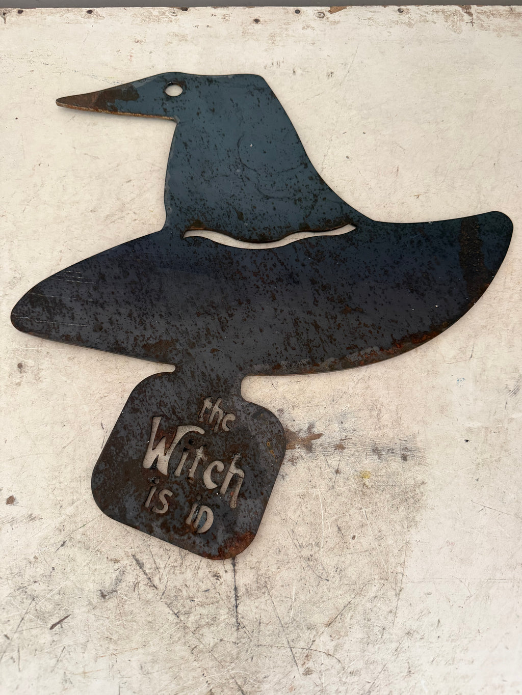 The witch is in metal sign