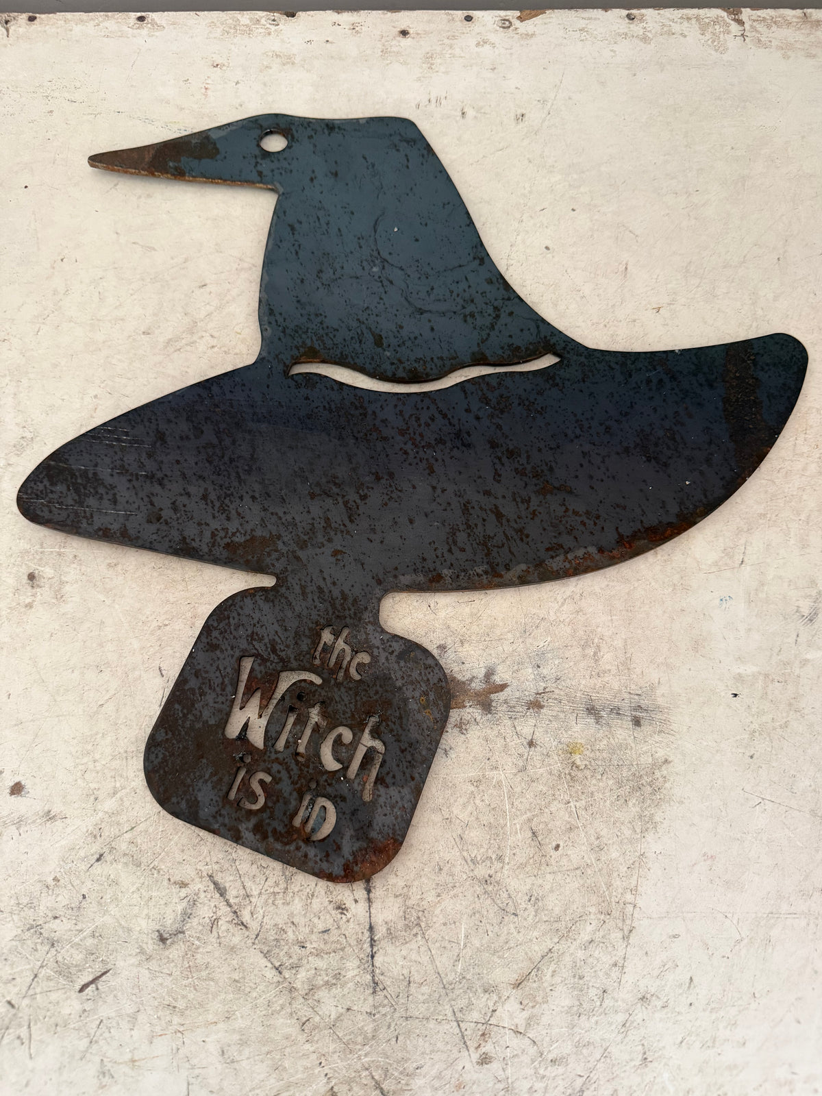 The witch is in metal sign