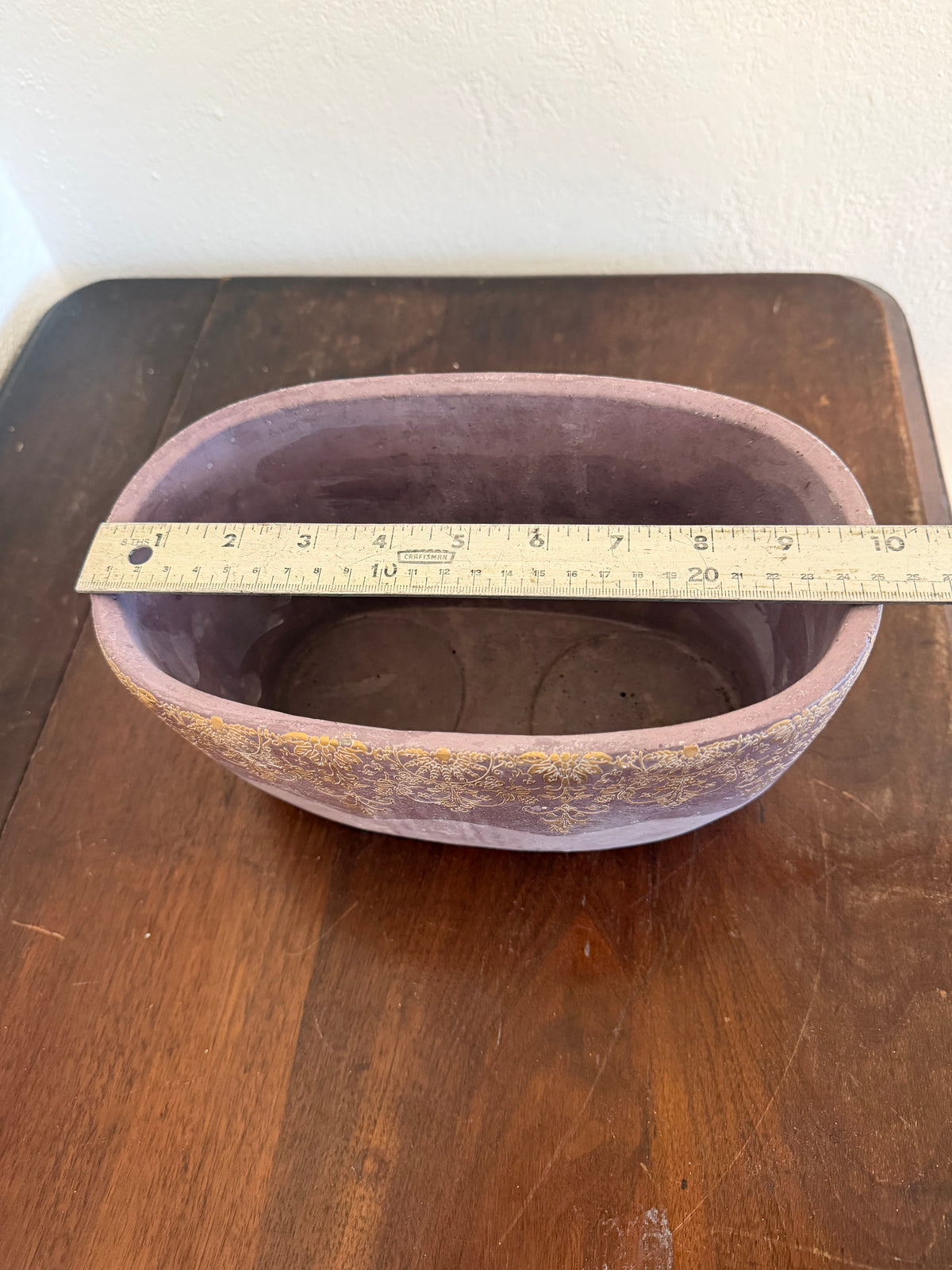 Cement planter with decorative design and purple hue