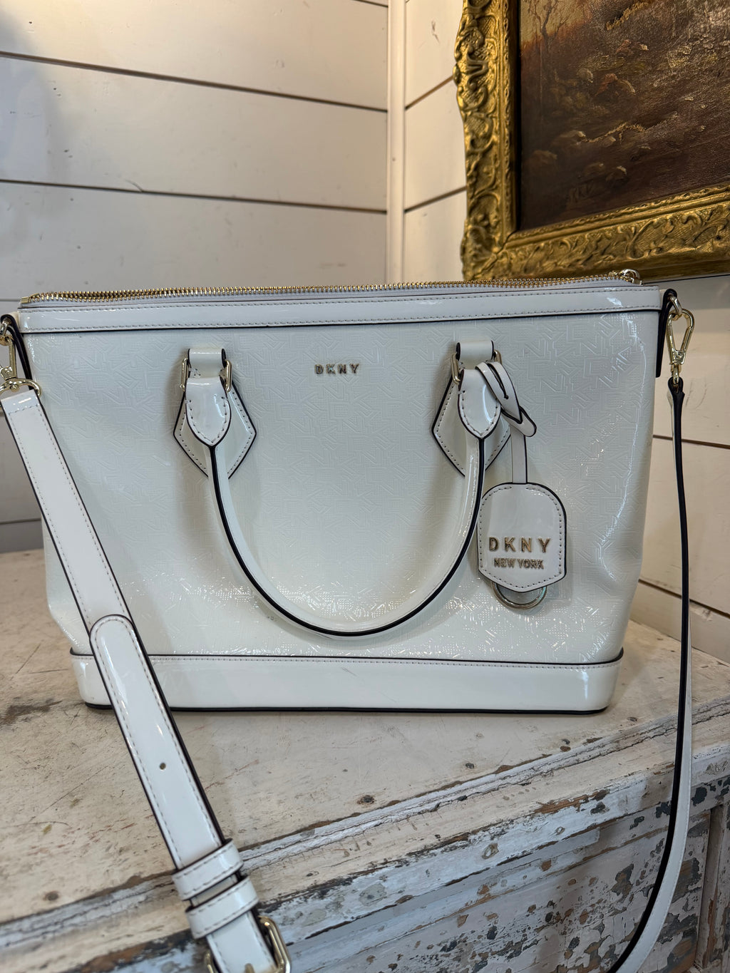DKNY Hadlee small tote bag in a patent material with a removable shoulder strap has small scuffs