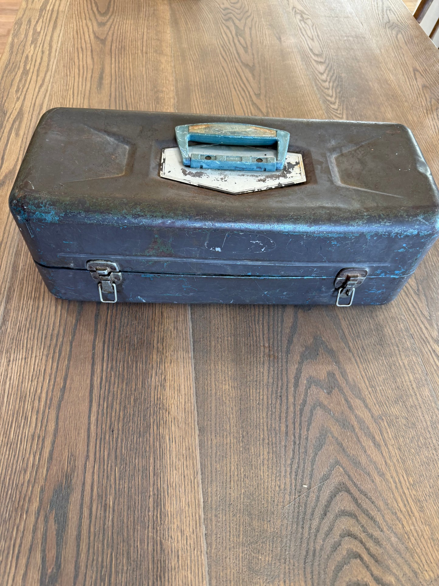 Vintage metal tackle box has dents and wear consistent with Age