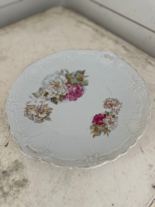 Vintage floral plate has imperfection on back as shown