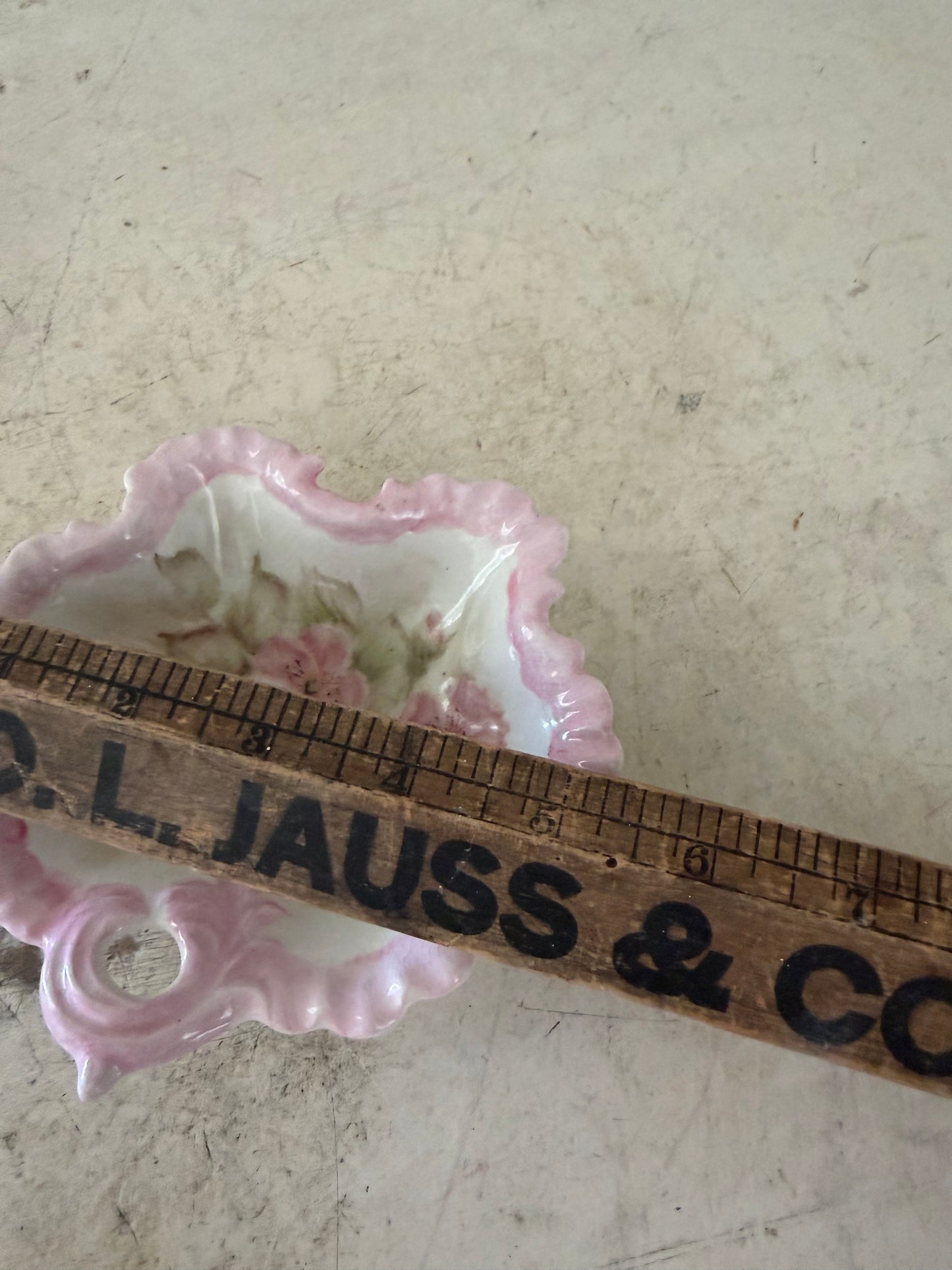 vintage pink and white floral porcelain bowl features a scalloped edge and a delicate handle