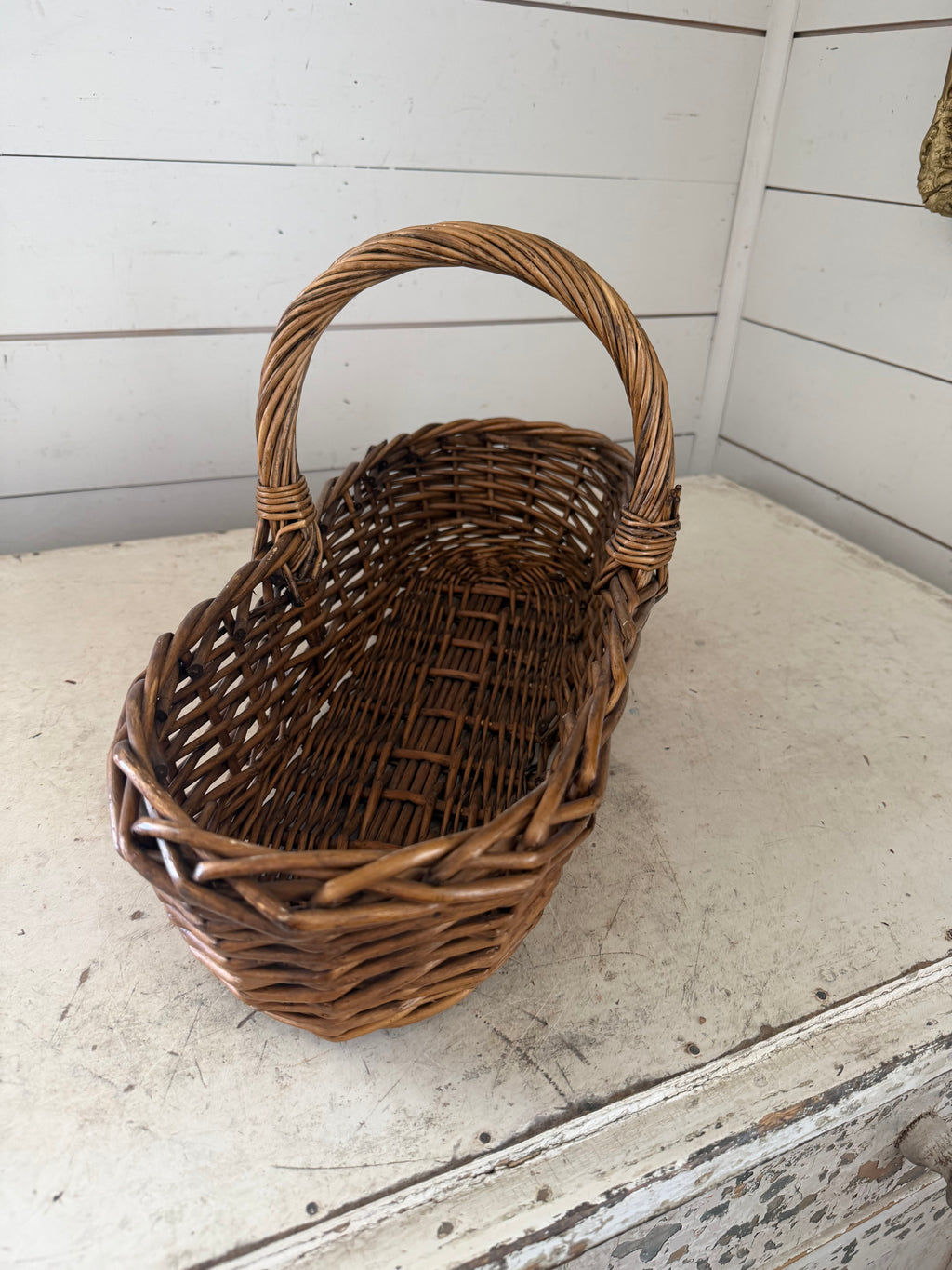 Long wicker gathering basket with handle in middle
