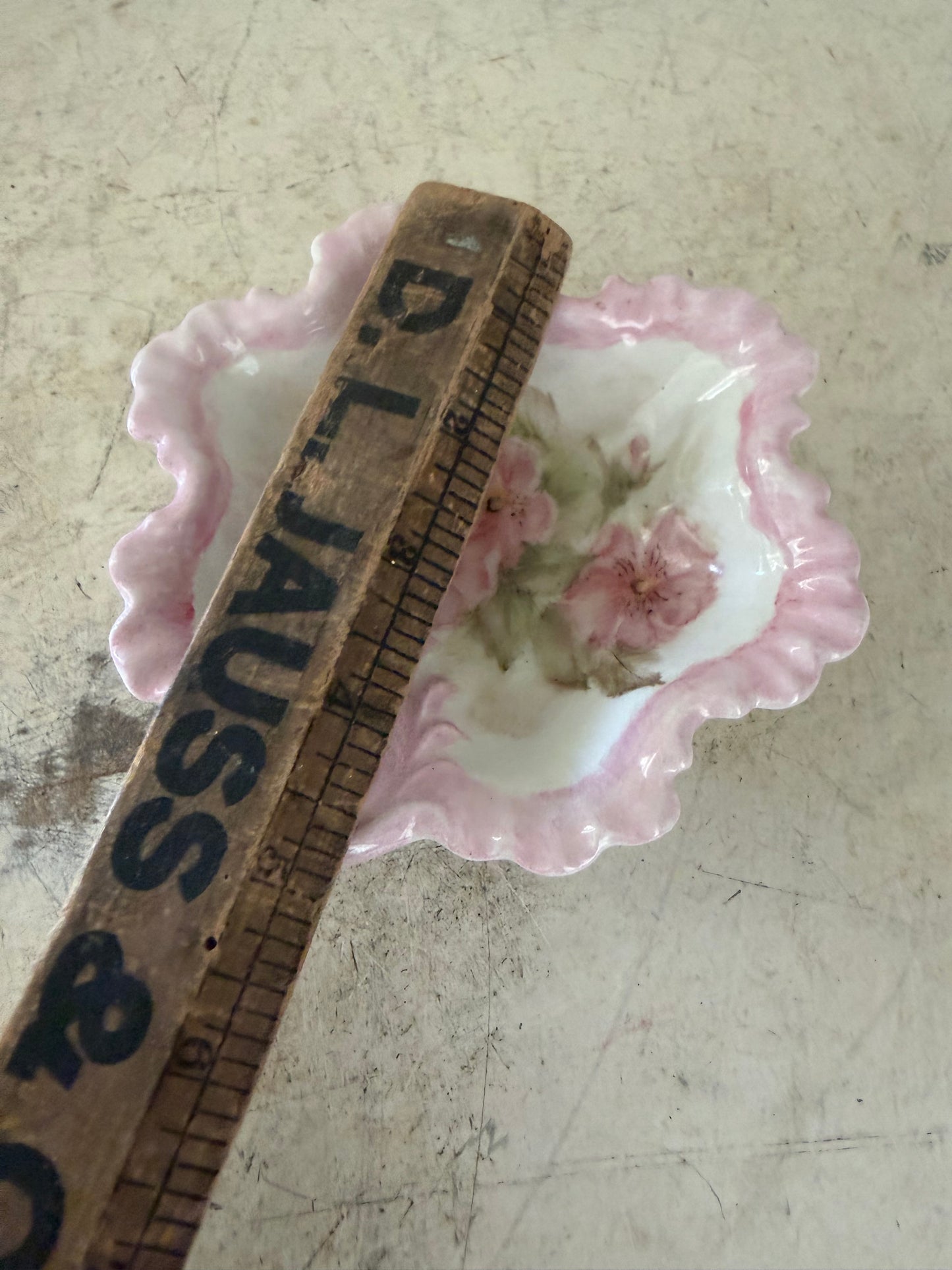 vintage pink and white floral porcelain bowl features a scalloped edge and a delicate handle