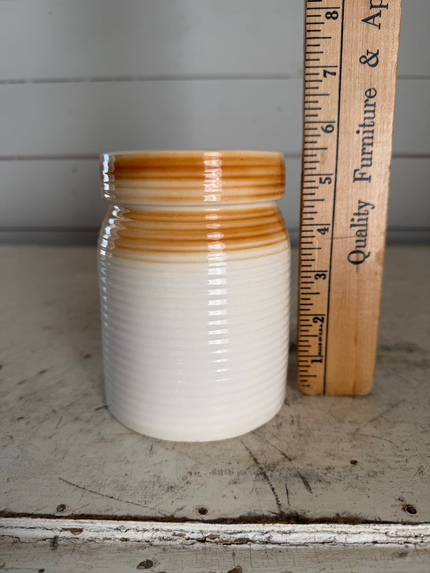 Small cream colored ribbed canister