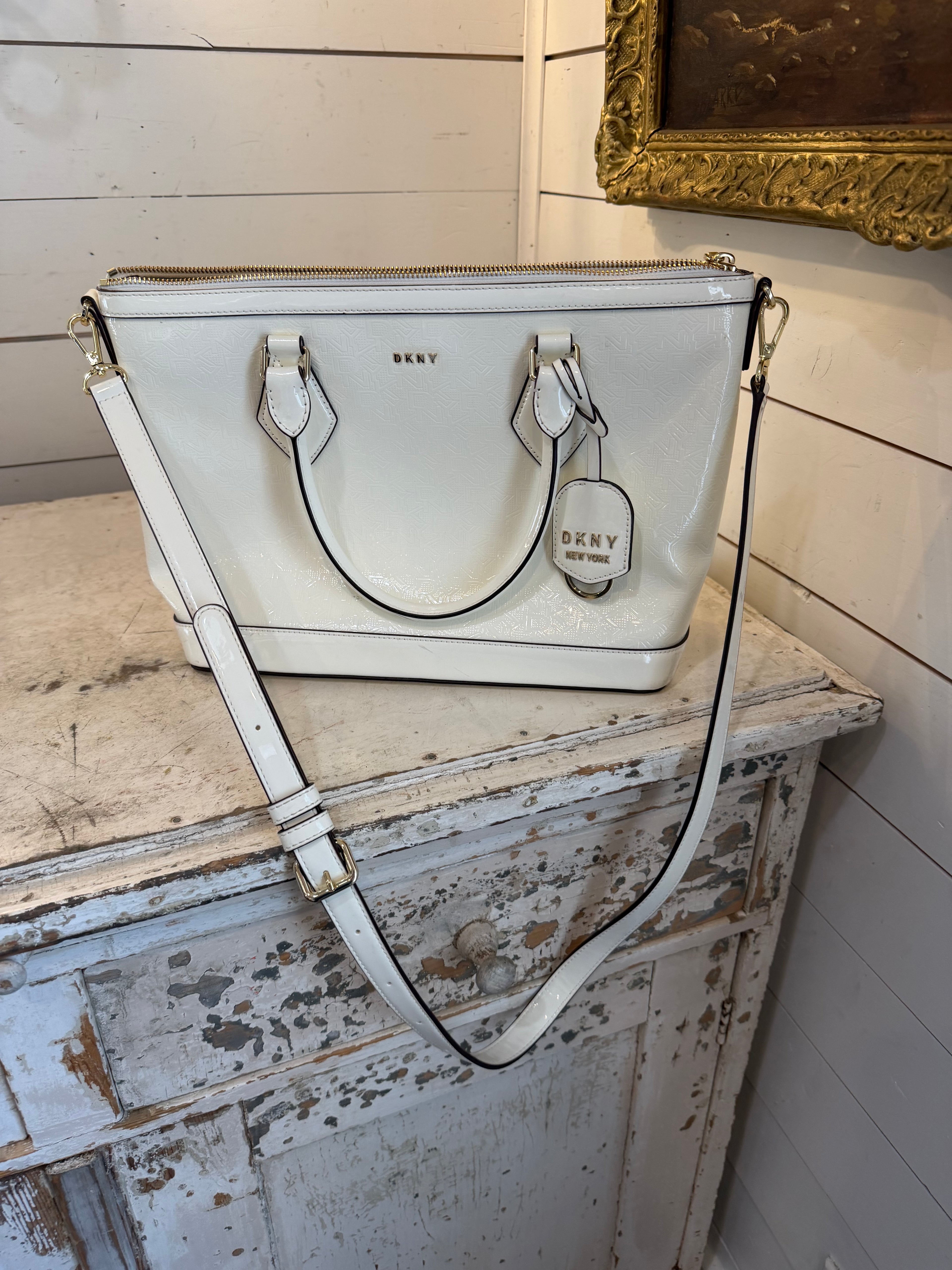DKNY Hadlee small tote bag in a patent material with a removable shoulder strap has small scuffs