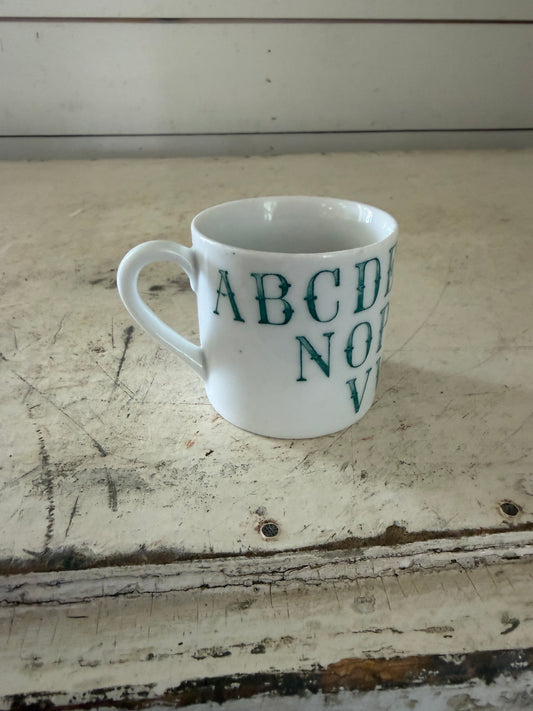 Vintage German porcelain alphabet mug featuring dark green transferware lettering