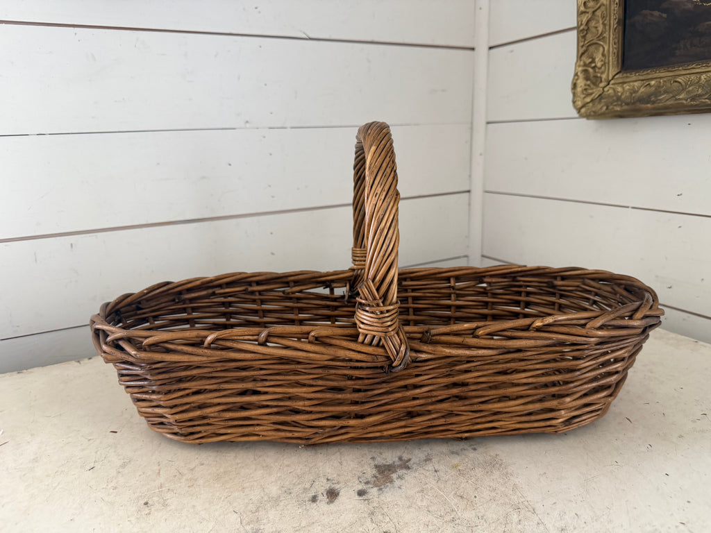 Long wicker gathering basket with handle in middle