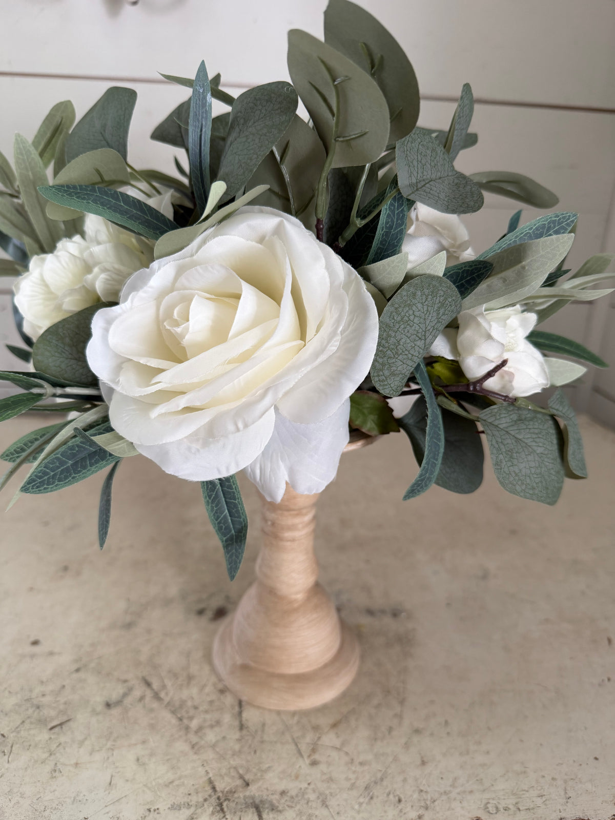 Turned wood pedestal with flowers on top
