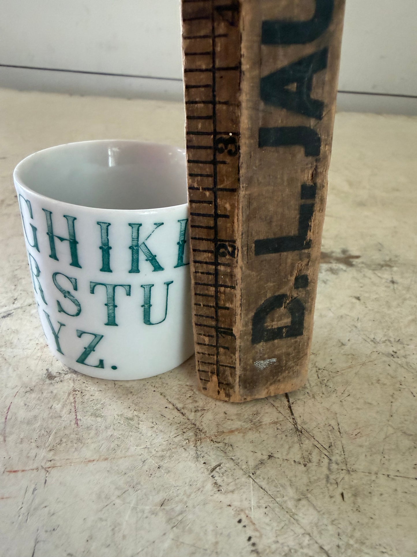 Vintage German porcelain alphabet mug featuring dark green transferware lettering