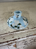 Blue candlestick with white flowers