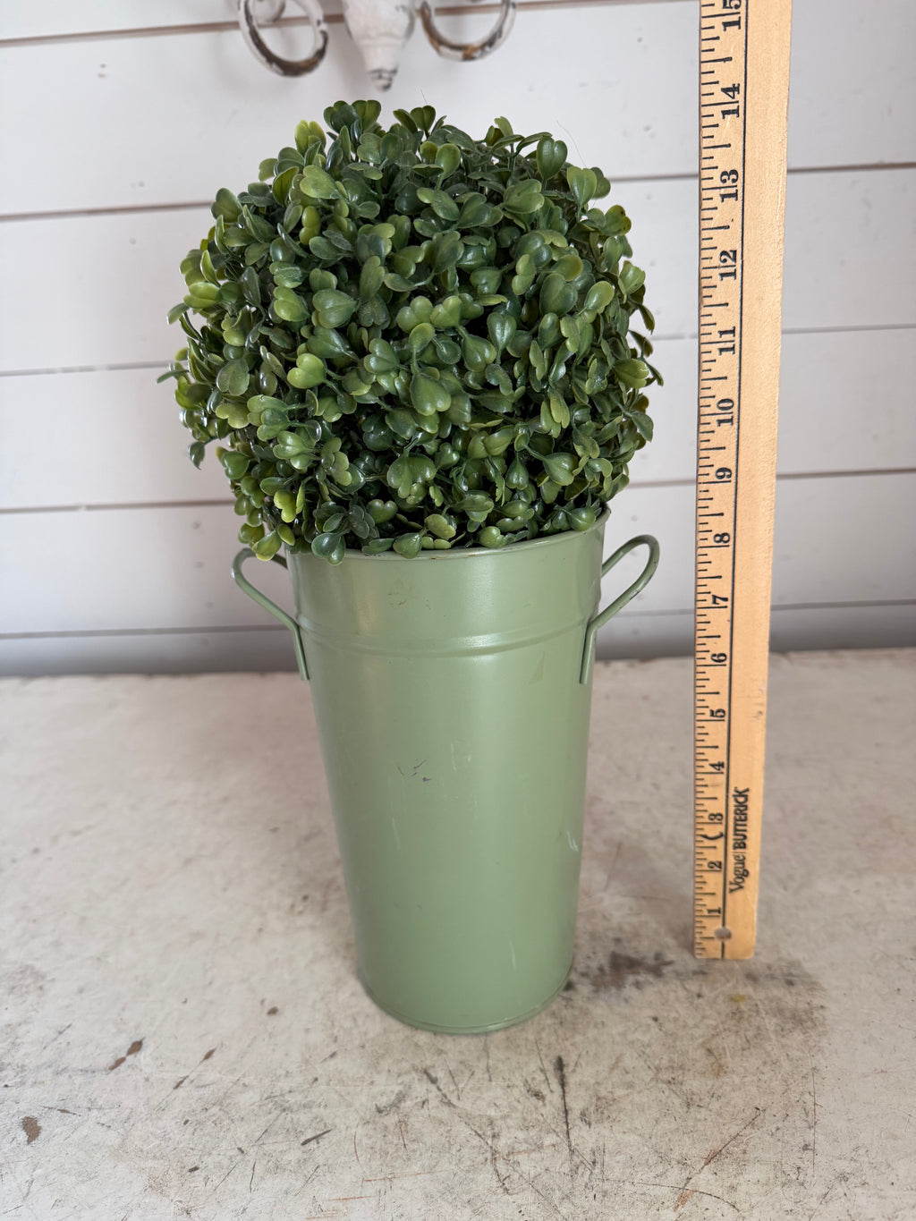 Artificial boxwood topiary in painted metal flower bucket