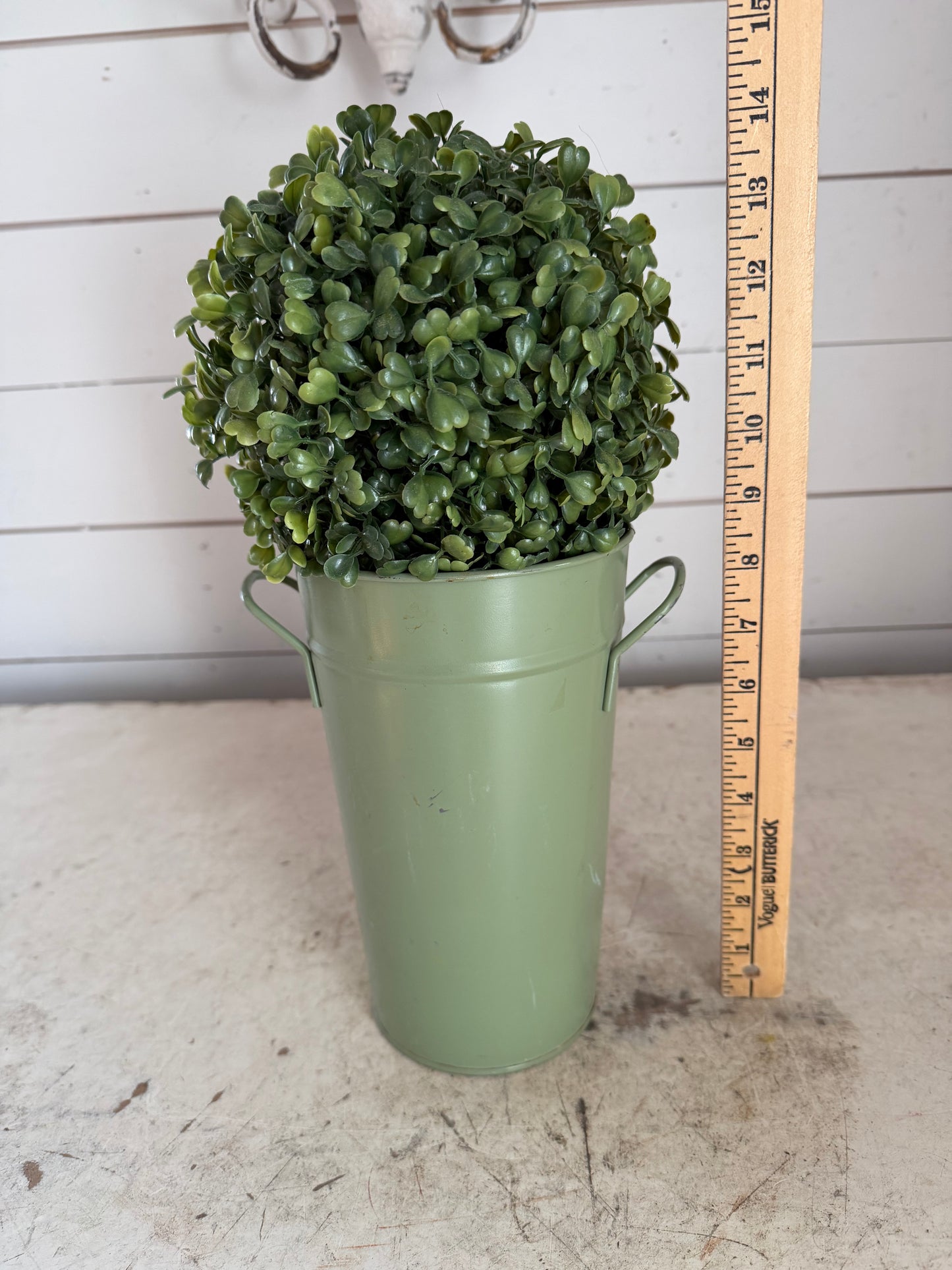 Artificial boxwood topiary in painted metal flower bucket