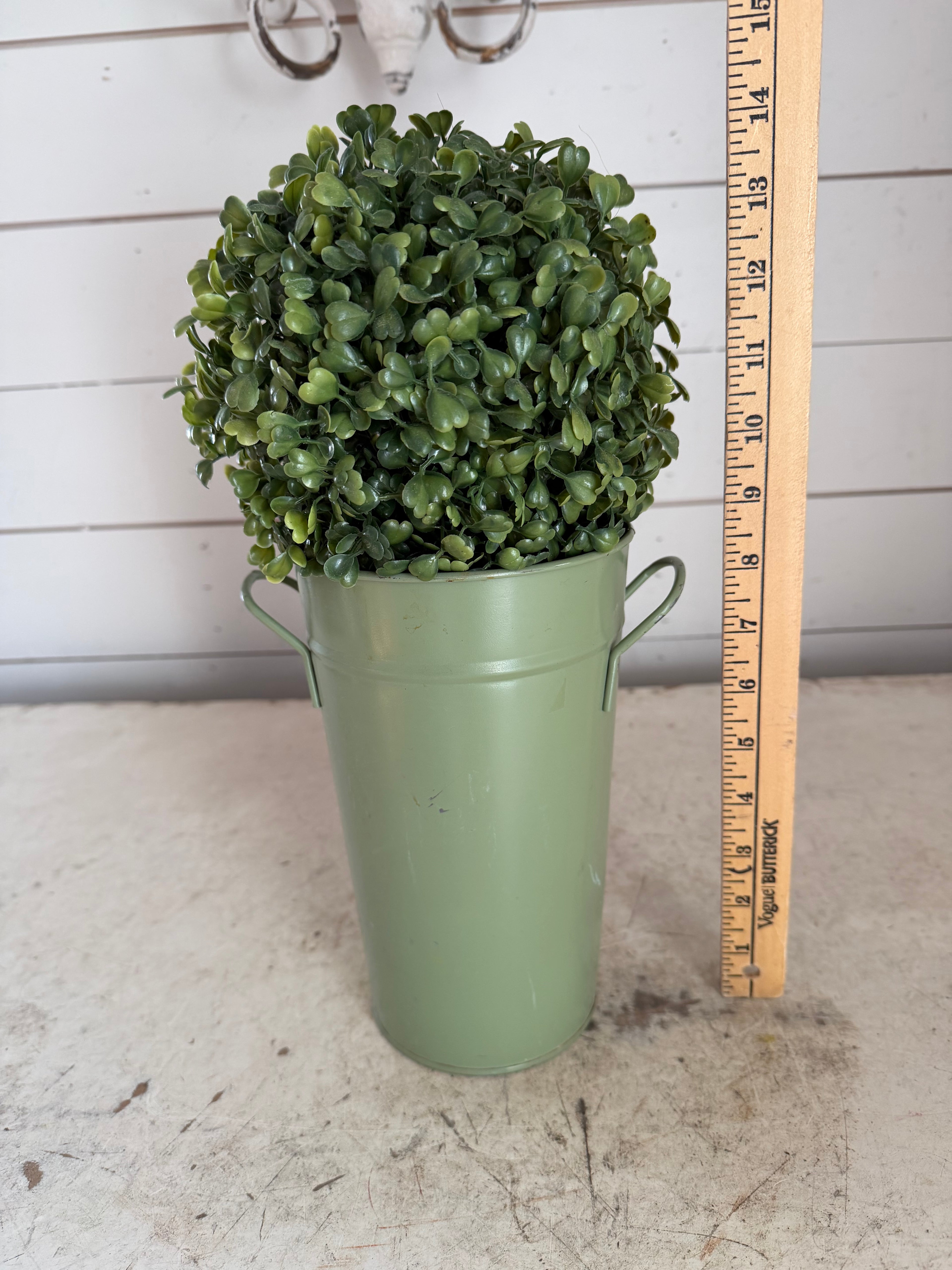 Artificial boxwood topiary in painted metal flower bucket