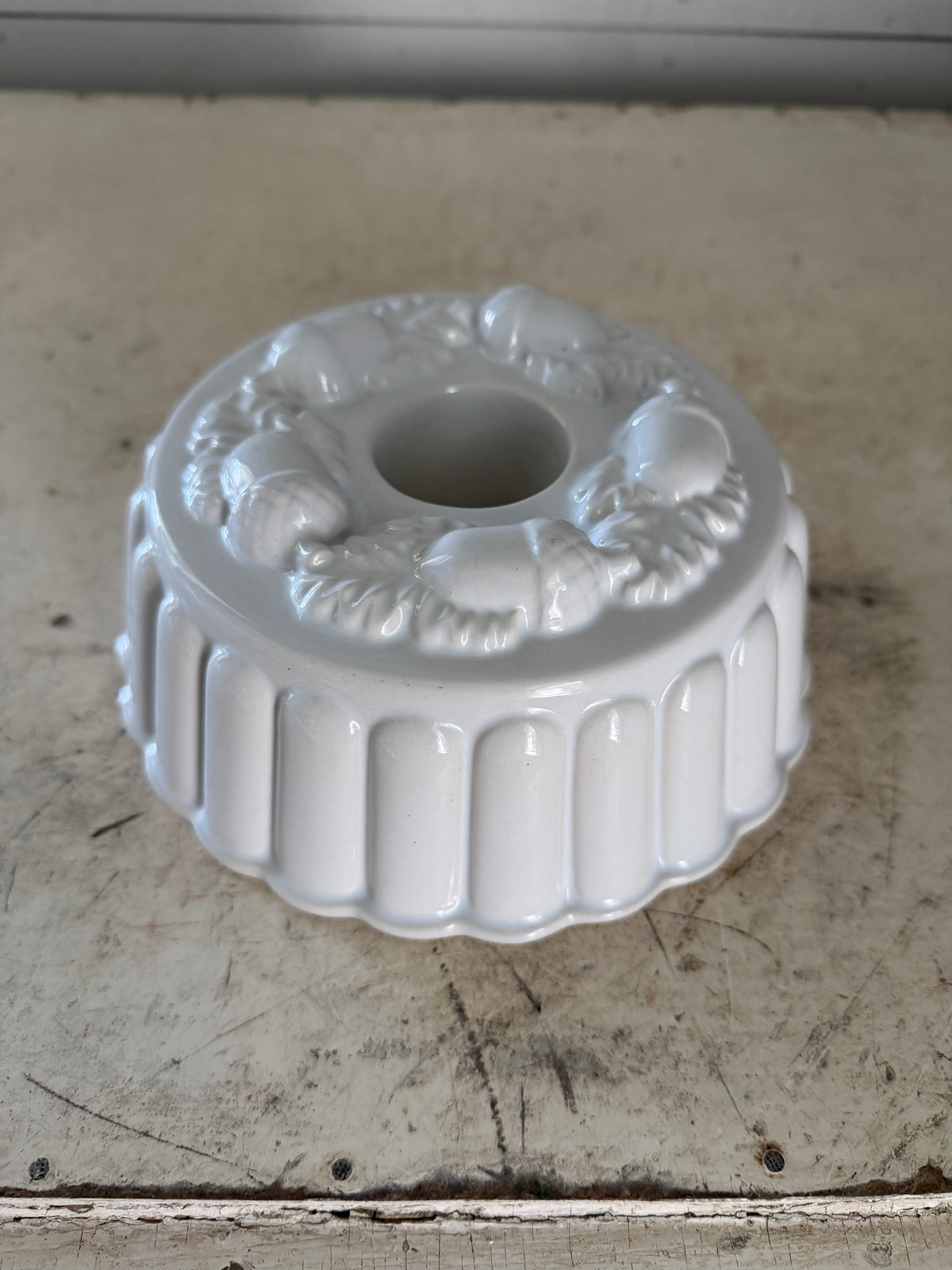White Ceramic ring mold decorated with a raised acorn and oak leaf pattern