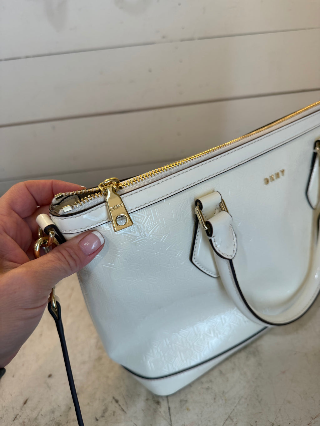 DKNY Hadlee small tote bag in a patent material with a removable shoulder strap has small scuffs