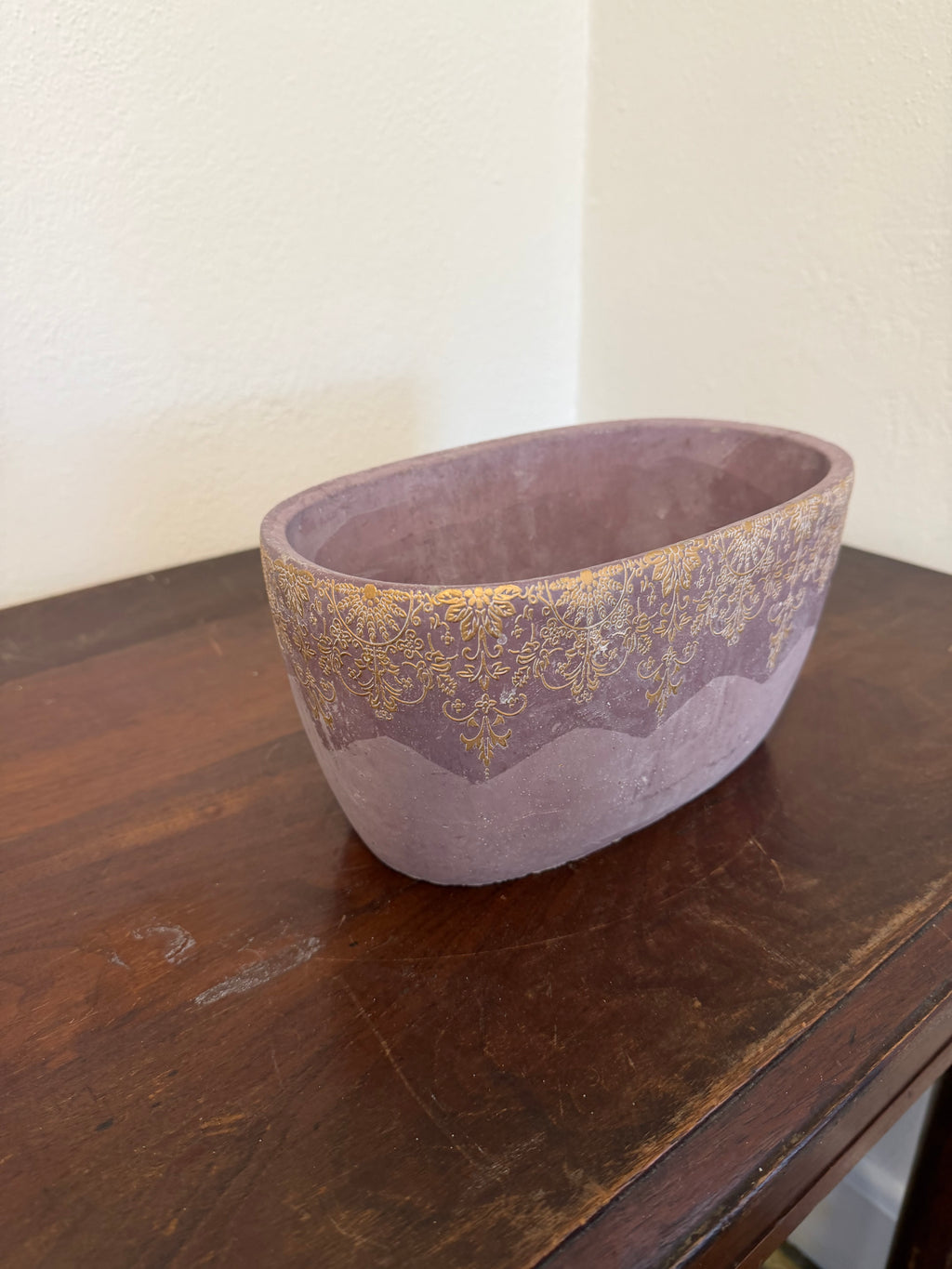 Cement planter with decorative design and purple hue