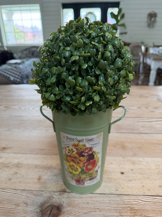 Artificial boxwood topiary in painted metal flower bucket